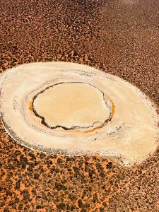 Circular salt flat in desert landscape